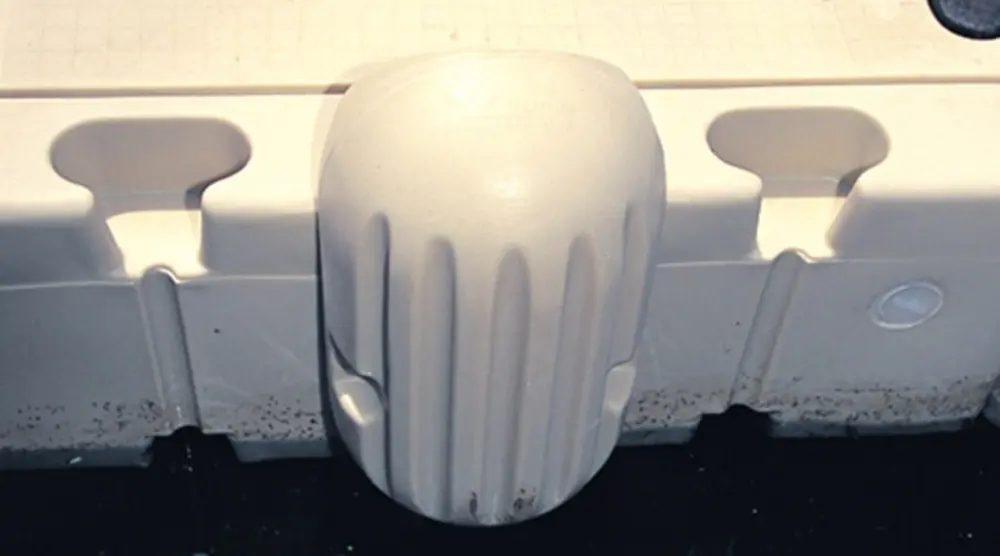 A white plastic object sitting on top of a floor.